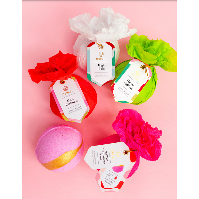 Holiday bath balms wrapped in colorful tissue with gift tags
