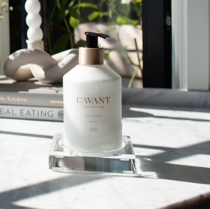 Small clear lucite tray holding a soap bottle on marble