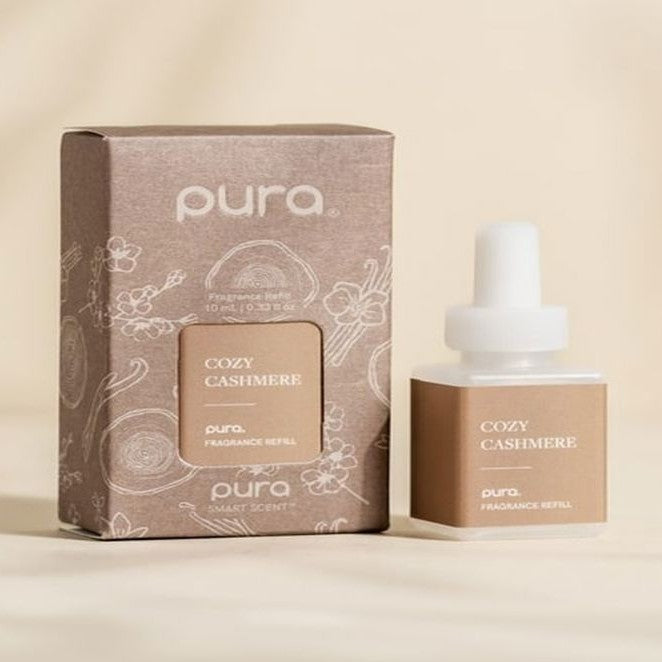 Pura Cozy Cashmere fragrance refill vial beside its taupe box