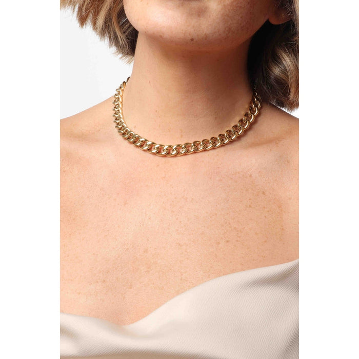 Model wearing a chunky gold curb chain choker