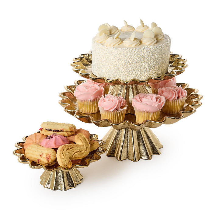 Gold scalloped two-tier cake stand with cake and cupcakes