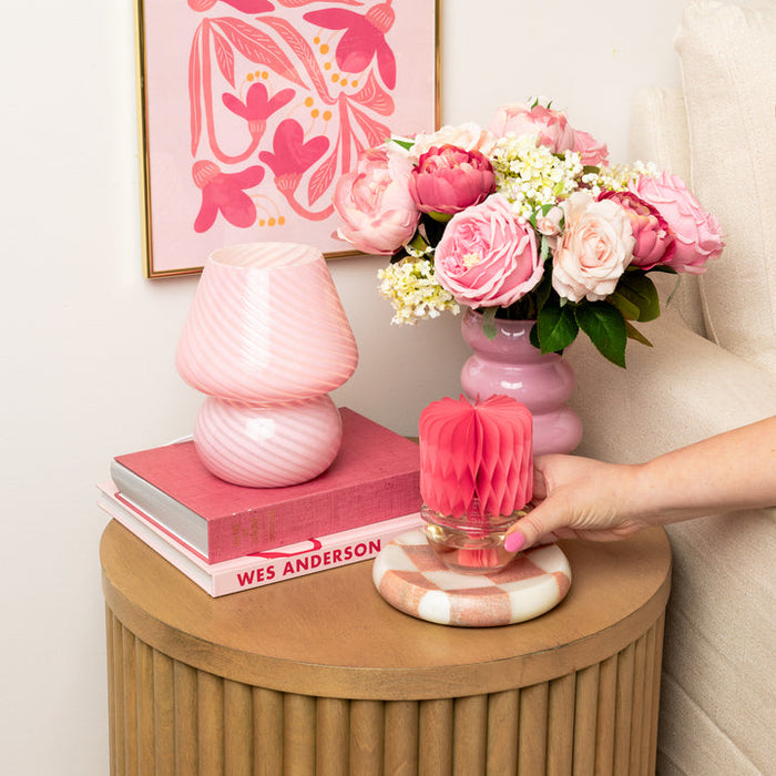 Red honeycomb Sweet Grace diffuser on a side table with pink roses and a pink lamp
