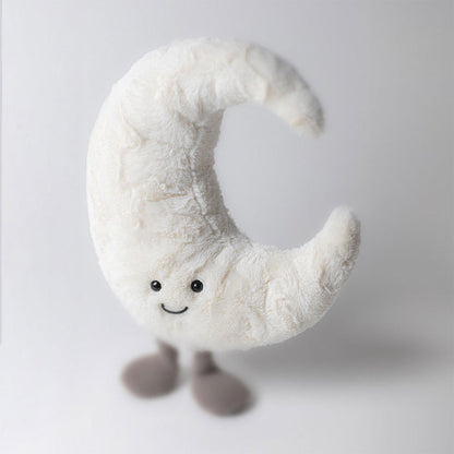 Crescent moon plush toy with a smiling face and small grey feet