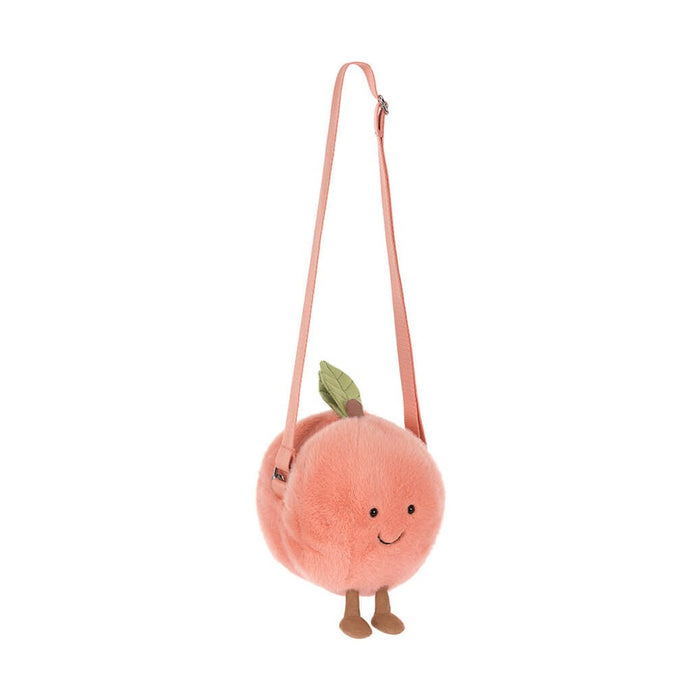 Plush peach shaped crossbody bag with a smiling face and dangling legs