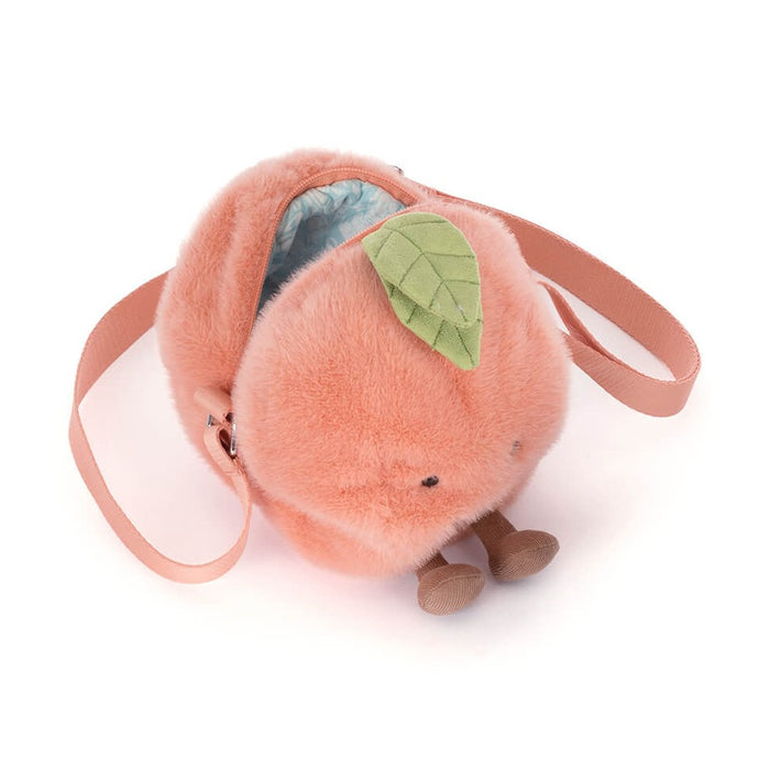 Plush peach shaped crossbody bag with a green leaf and small brown dangling legs