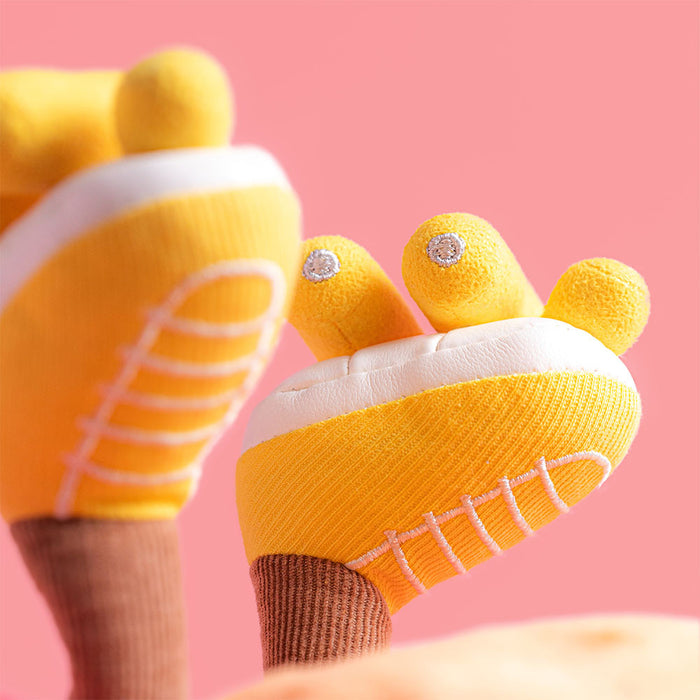 Pair of yellow baby socks designed to look like sneakers with brown cuffs