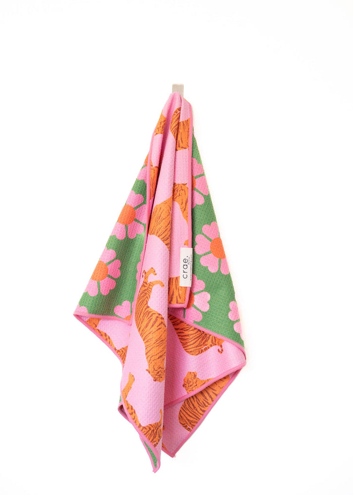 Pink and green hand towel with tigers and flowers, hanging