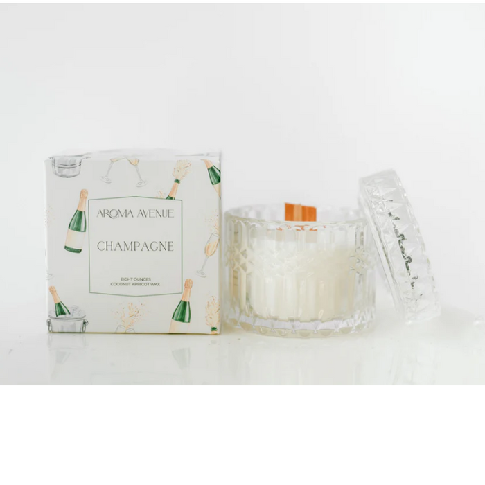 Champagne candle in a faceted glass beside its white gift box