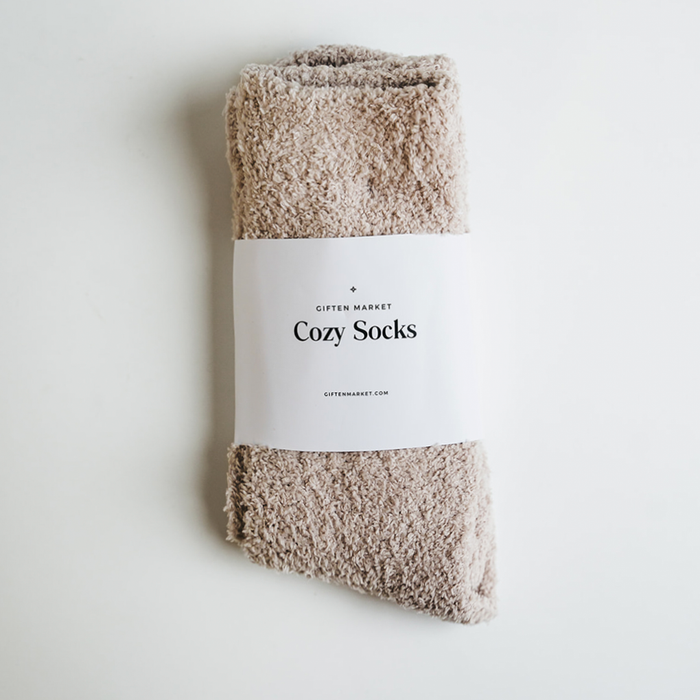 Beige fuzzy socks wrapped in a white paper band with Giften Market branding