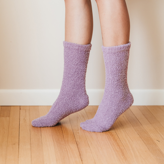 Person wearing orchid purple fuzzy socks