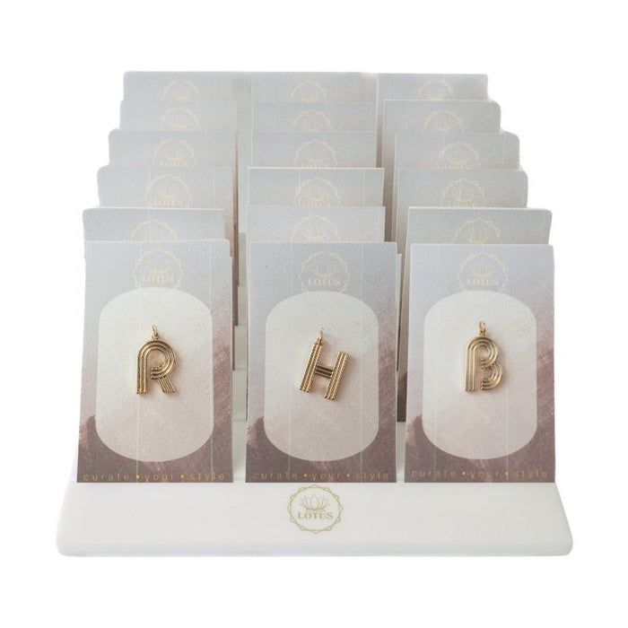 Deco letter pendants displayed on cards in a white stand