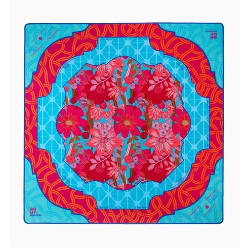 Delilah mahjong mat with a red floral center and turquoise and red borders