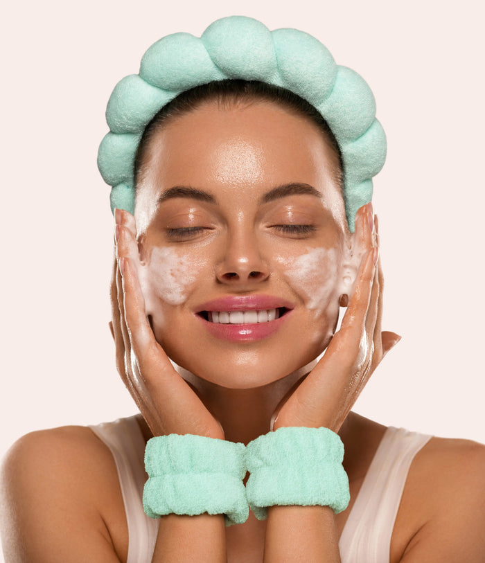 Smiling woman in a green puffy spa headband and wristbands