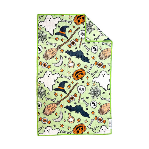 Lime green hand towel printed with witch hats, brooms, bats, ghosts and candy