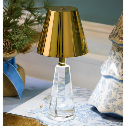 Cordless crystal lamp with a gold shade on a table with blue and white decor