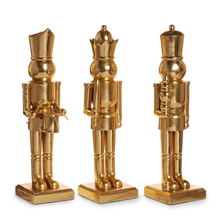 Three gold nutcracker figurines on square bases