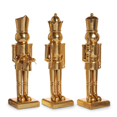 Three gold nutcracker figurines on square bases