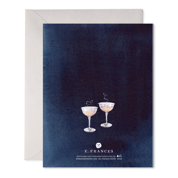 Back of a navy card with two pink champagne coupes