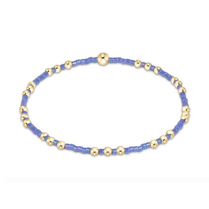 Gold beaded stretch bracelet with periwinkle seed bead sections