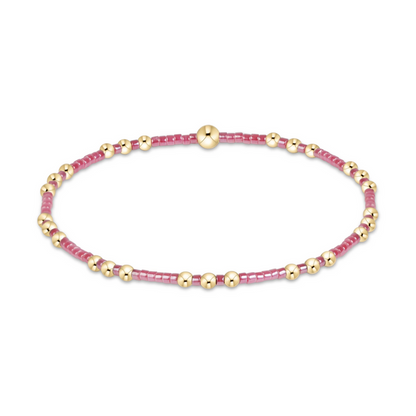 Gold beaded stretch bracelet with berry pink seed bead sections