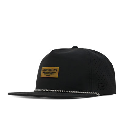 Black five panel snapback hat with perforated side panels and a tan branded patch on the front