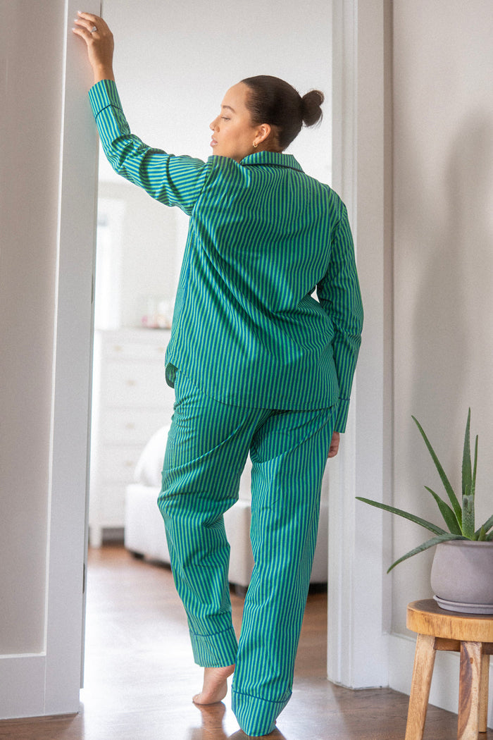Back view of model in the green and navy striped pajama set