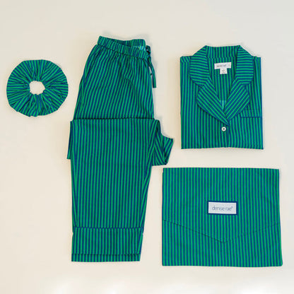 Striped pajama set laid flat with matching scrunchie and travel pouch