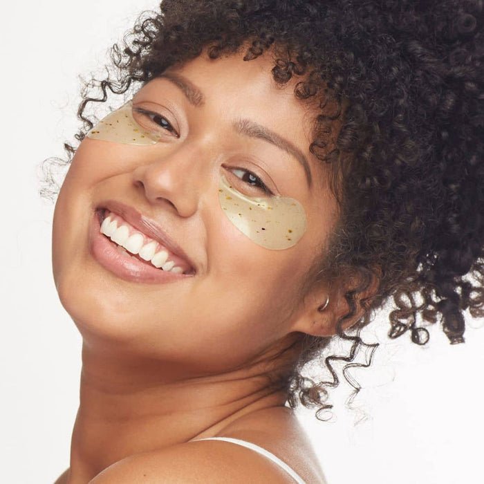 Smiling woman wearing green under-eye gel patches