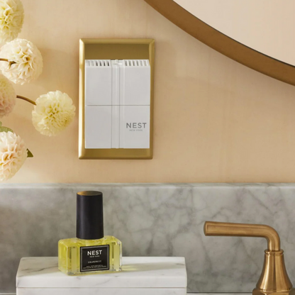Nest New York wall diffuser and grapefruit fragrance refill bottle on a marble counter