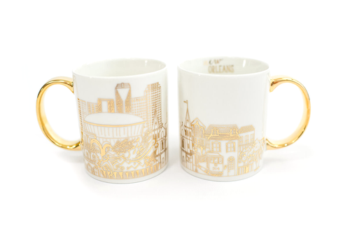 Two white mugs with a gold New Orleans skyline design and gold handles