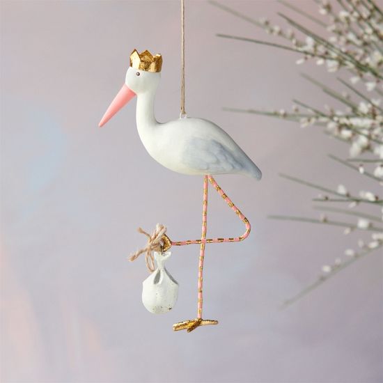 White stork ornament with a gold crown carrying a baby bundle