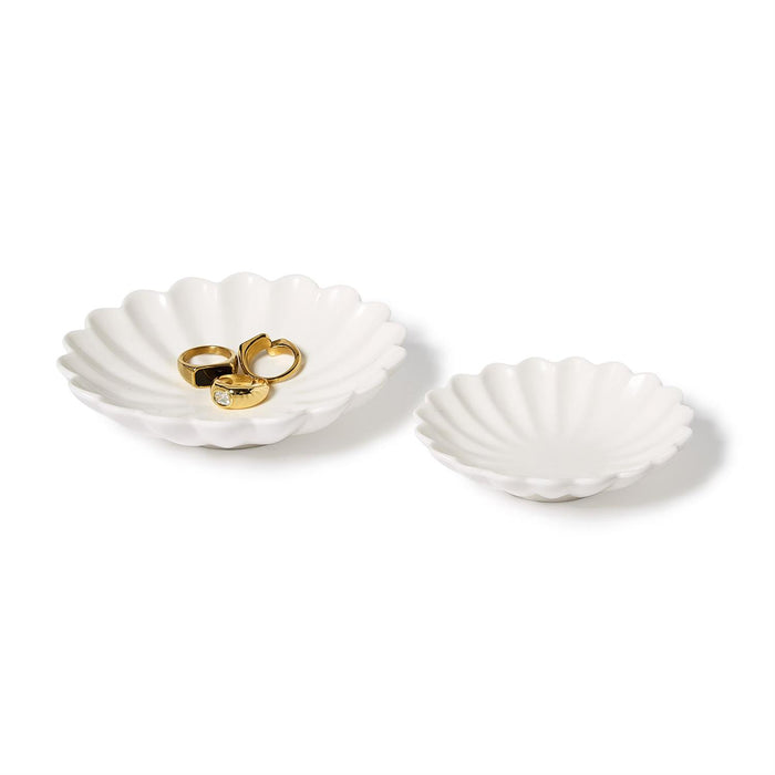 Two white scalloped shell tidbit dishes, one holding gold rings