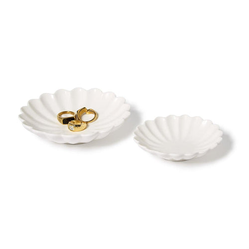 Two white scalloped shell tidbit dishes, one holding gold rings