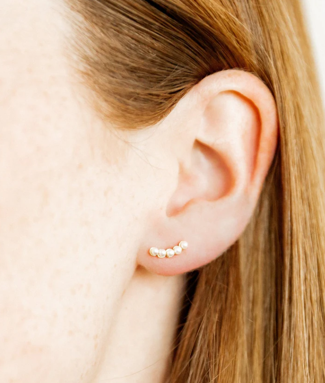 Model wearing a gold pearl climber stud