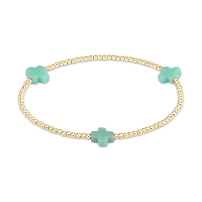 Gold beaded stretch bracelet with three mint green cross charms