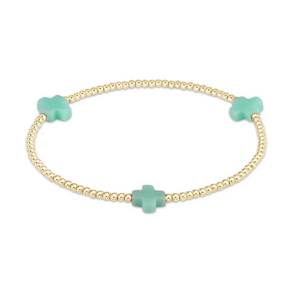 Gold beaded stretch bracelet with three mint green cross charms