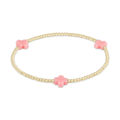 Gold beaded stretch bracelet with three light pink cross charms