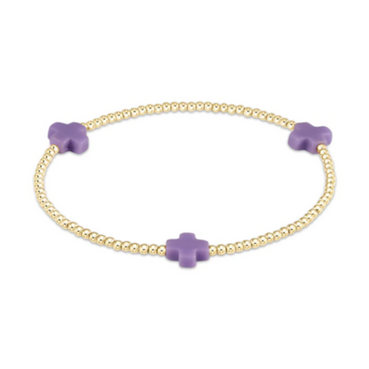 Gold beaded stretch bracelet with three purple cross charms
