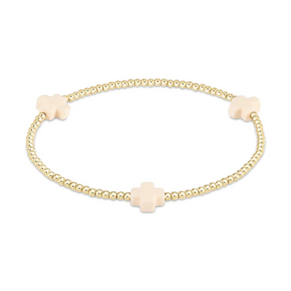 Gold beaded stretch bracelet with three cream cross charms