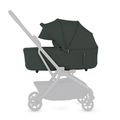Side profile of a dark green stroller bassinet mounted on a faded stroller frame.
