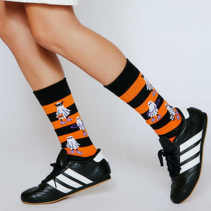 Person wearing orange striped ghost socks with black sneakers