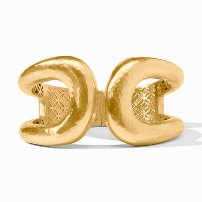 Gold cuff bracelet with a hammered texture and geometric pattern interior