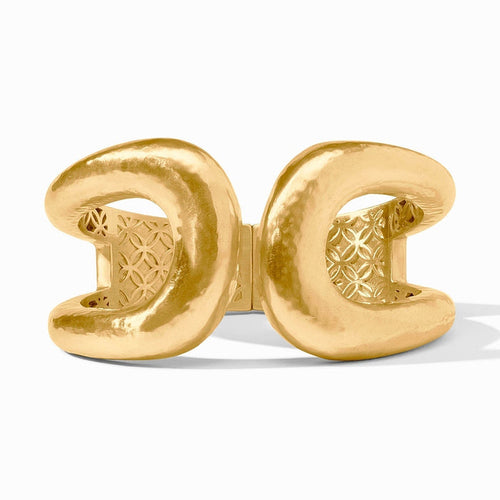 Gold cuff bracelet with a hammered texture and geometric pattern interior