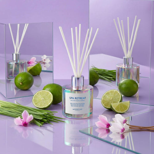 Moodcast Spa Retreat reed diffusers on a purple display with limes