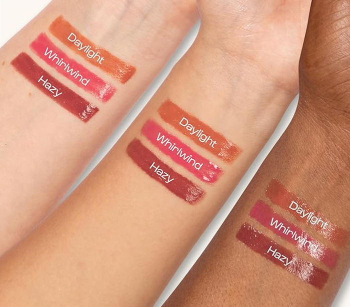 Three lipstick shades named Daylight Whirlwind and Hazy swatched on three different skin tones