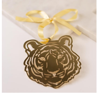 Gold metal tiger head ornament with a yellow ribbon