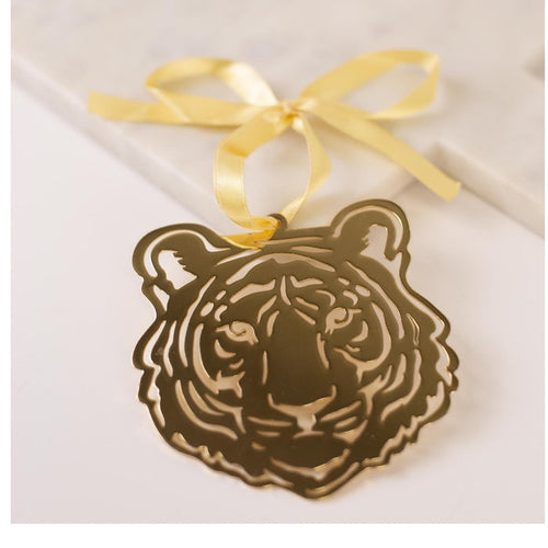 Gold metal tiger head ornament with a yellow ribbon