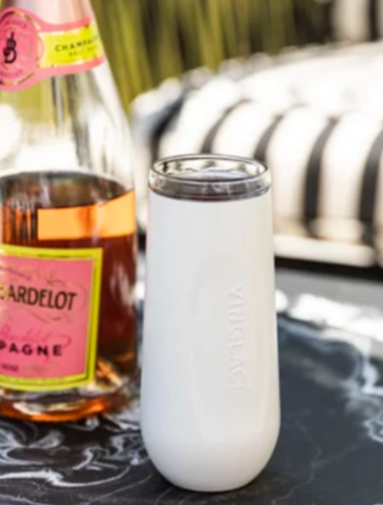 White insulated champagne flute beside a champagne bottle