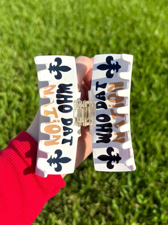 White hair claw clip with black fleur de lis symbols and Who Dat Nation text